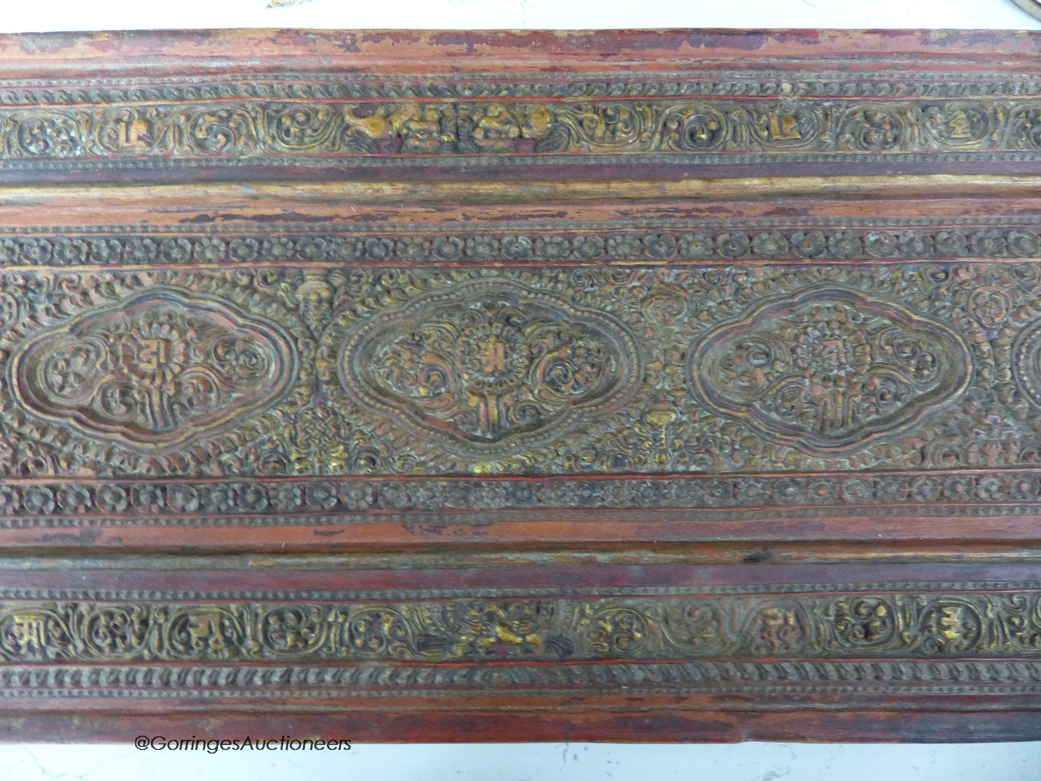 A 15th/16th century Tibetan carved and lacquered wood cover for a sutra box, 72 x 24cm